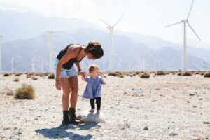 Ethical Maxims for the Climate Crisis feature image of woman and child in front of wind turbines