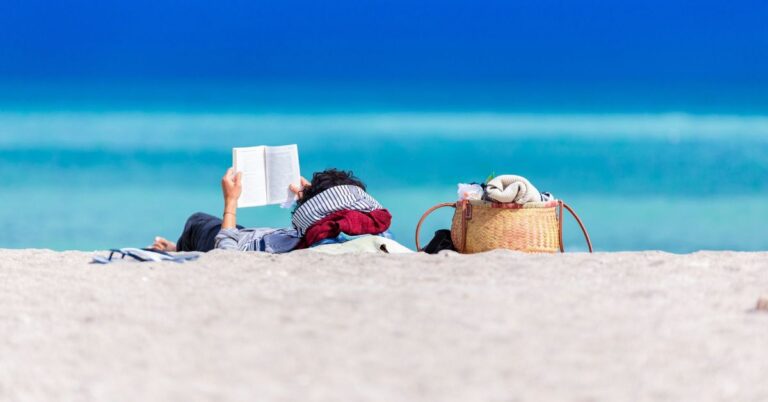 image of person reading on the beach