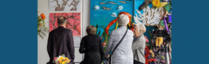 people looking at a mural from the Neighbourhood in the 21st Century fundraiser dinner
